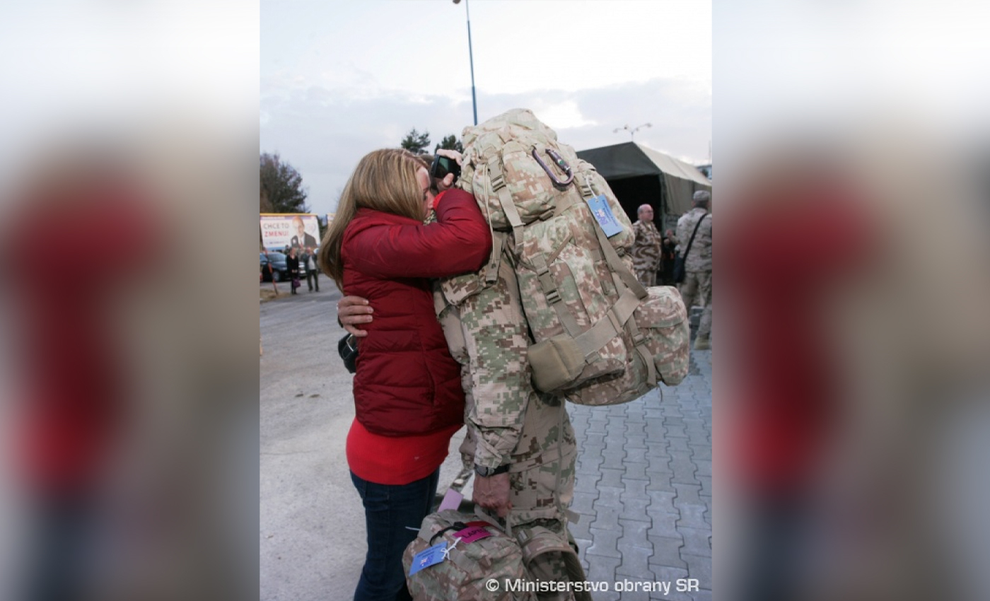 An image shows a Ukrainian soldier bidding farewell and kissing the stomach of his pregnant wife.