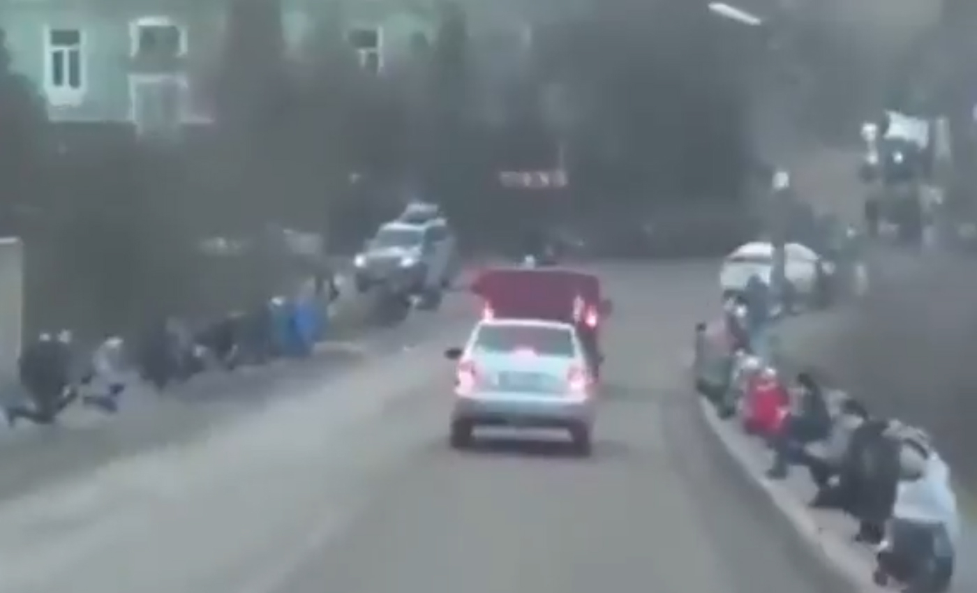 This video shows Ukrainians kneeling on the sidewalk as a vehicle transports a crucifix from a cathedral in Kyiv amid Russia's invasion.