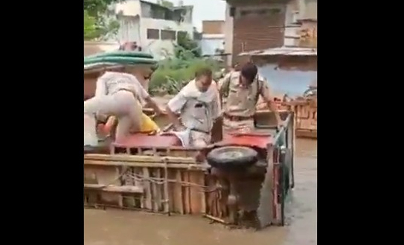 A video shows U.P. Police officers rescuing themselves from an overturned vehicle in a flooded street.
